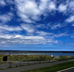 A view of a pier extending over water with grass in the foreground at Bay View in Amble