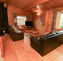 A living room with a sofa and television at Heather Cottages - Brown Owl Bamburgh