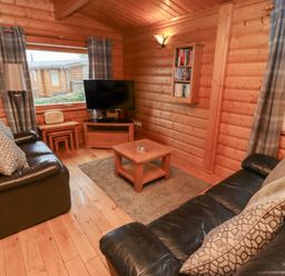 A living room with a TV and coffee table at Heather Cottages - Brown Owl in Bamburgh