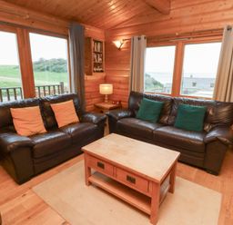 A living room with sofas and a coffee table at Heather Cottages - Grey Heron in Bamburgh