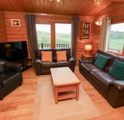 A living room with a television and sofas at Heather Cottages - Grey Heron in Bamburgh