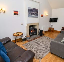 A living room with a sofa and fireplace at Heather Cottages - Grey Seal in Bamburgh