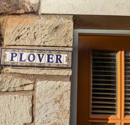 A nameplate on a stone wall at Heather Cottages - Plover in Bamburgh