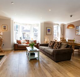 A living room with two sofas a coffee table and a dining table with chairs at Upper Alnbank in Alnmouth