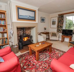 A living room with a fireplace and bookshelf at St Marys Cottages No4 Low Newton-by-the-Sea