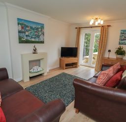A living room with a television and a rug at Sugar Sands in Longhoughton