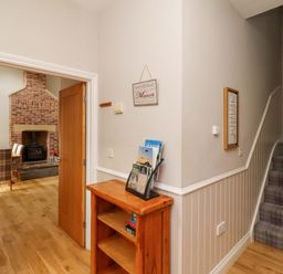 A hallway with bookshelf and staircase at Roe Deer in Lucker