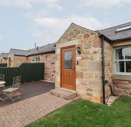 An entrance with a door and patio furniture at Chiff Chaff in Lucker