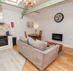 A living room with a sofa and dining table at Chiff Chaff in Lucker