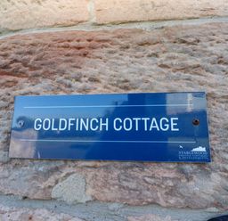 A sign with the name Goldfinch Cottage at Goldfinch in Lucker
