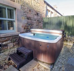 A hot tub with steps outside at Goldfinch in Lucker
