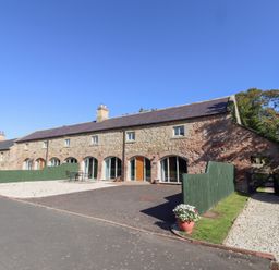 An outdoor area in front of a stone building at Bullfinch in Lucker