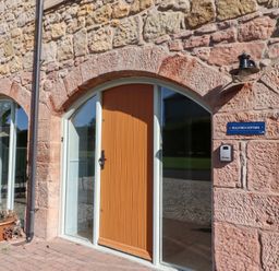 An entrance with a brown door and a sign at Bullfinch in Lucker