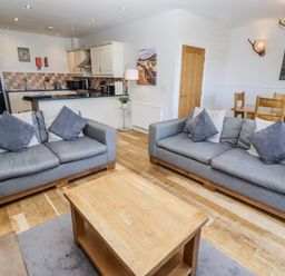 A living room with a sofa and coffee table at Jackdaw in Bamburgh