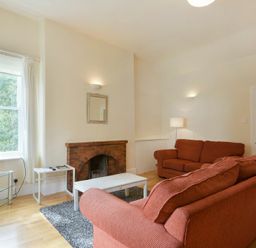 A living room with two sofas a fireplace and a television at Decked Out in Alnmouth