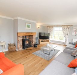A living room with a fireplace a television sofas and a coffee table at Jara in Bamburgh
