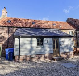 A cottage exterior with gravel area at Millstone in Lucker