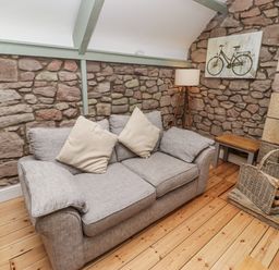 A living room with a sofa and a side table at Millstone in Lucker