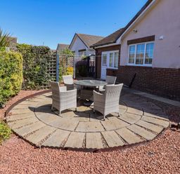 A garden with a table and chairs on a stone patio at 6 Westview in Embleton
