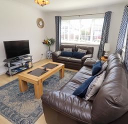 A living room with a television and coffee table at 6 Westview Embleton