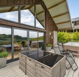 An outdoor area with hot tub and furniture at Bwncath in Garthmyl