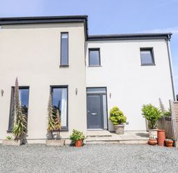 A modern house with windows and plants at Bryn Mor in Benllech