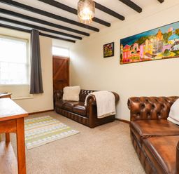 A living room with a TV and sofas at 11- 13 High Street