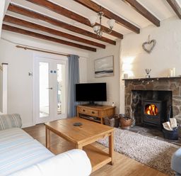 A living room with a fireplace and sofa at Riverside Cottage in Beddgelert