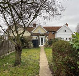 A garden path leading to a cottage with multiple sections and a tiled roof at 2 Mosses Cottage in Friston