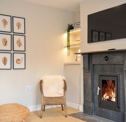 A living room with a fireplace and a television at Mermaid Cottage in Port Isaac