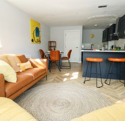 An open plan living room and kitchen with a sofa dining table and kitchen island at Flat 6 Thornlow Heights in Weymouth