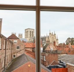 View of rooftops and York Minster cathedral through a window at 6 Granary Court in York