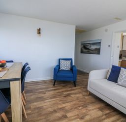 A living room with a dining table and chairs at Sunset Sea View Chalet in Millbrook