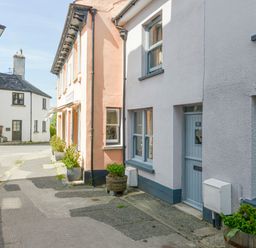 A street with buildings featuring windows and doors and bicycles parked on the sidewalk at The Cottage on The Square in Chagford