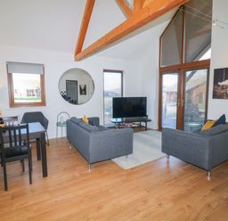 A living room with a dining table and sofa at Lodge 1 in South Hykeham