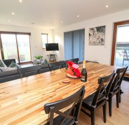 A dining room with a table and sofa at Lodge 2 in South Hykeham