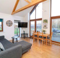 A living room with a sofa, coffee table, and dining area at Lodge 3 Thorpe-On-The-Hill