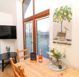 A dining room with a table and television at Lodge 3 Thorpe-On-The-Hill