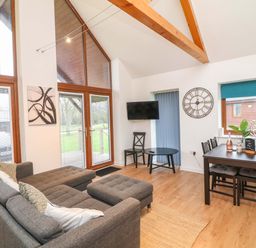 A living room with a sofa and dining table at Lodge 4 South Hykeham