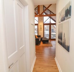 A hallway leading to a living area with large windows at Lodge 7 in South Hykeham