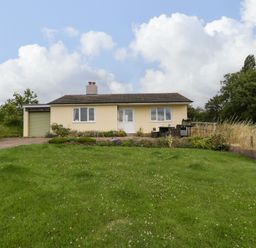 A single-story house with a garden and patio furniture on a grassy lawn at Palace Bungalow in St Weonards