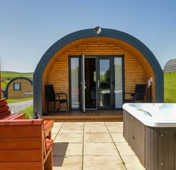 An outdoor area with a hot tub and a wooden cabin at Willow in Ulverston