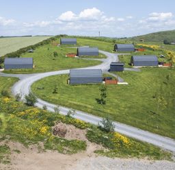 An outdoor area with cabins and a dirt path at Oak in Ulverston