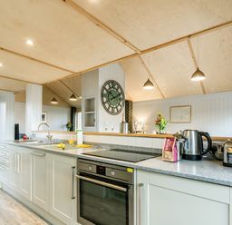 A kitchen with a stove oven kettle toaster and sink at Lodge 3 Corfe Castle