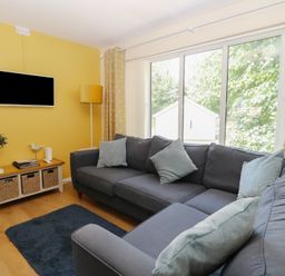 A living room with a sofa and television at 15 The Dell in Mundesley