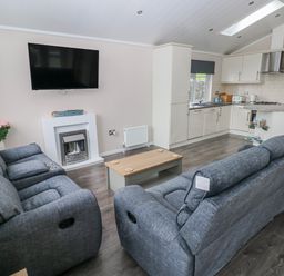 A living room with a sofa and coffee table at Dono's Lodge, Stepaside near Kilgetty, Heritage Park