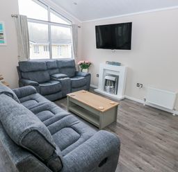 A living room with a sofa and coffee table at Dono's Lodge, Stepaside near Kilgetty, Heritage Park