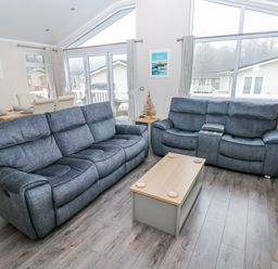 A living room with a sofa and coffee table at Dono's Lodge Stepaside near Kilgetty Heritage Park