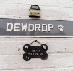 A nameplate and welcome sign mounted on a wall at 22 Longstone Park Beadnell