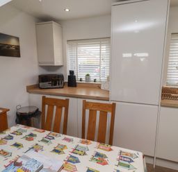A kitchen with a dining table and chairs at 22 Longstone Park Beadnell